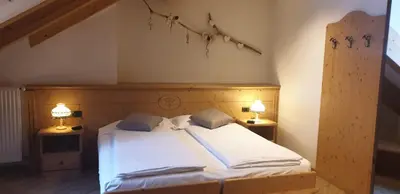 a bedroom with a bed with two lamps on both sides at Albergo Bernard in Canazei