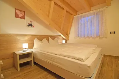 a bedroom with a large bed in a attic at Vacanze Arcobaleno in Predazzo