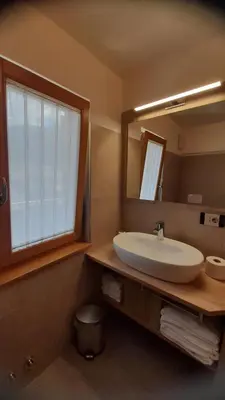 a bathroom with a white sink and a mirror at Vacanze Arcobaleno in Predazzo