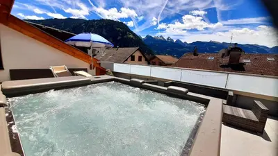 a hot tub on top of a building with mountains at Vacanze Arcobaleno in Predazzo
