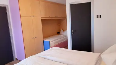 a small bedroom with a bed and a closet at Vacanze Arcobaleno in Predazzo