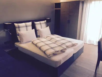 a bed with white pillows and a blanket on it at Pension Hauenstein in Lagundo