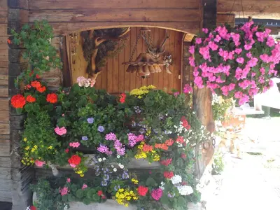 a statue of a cross on a pole with flowers at Appartamenti Hacoli in Selva di Val Gardena