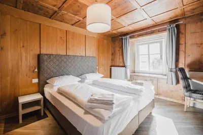 a bedroom with a large bed in a room with wooden walls at Casa Dorich in Pozza di Fassa