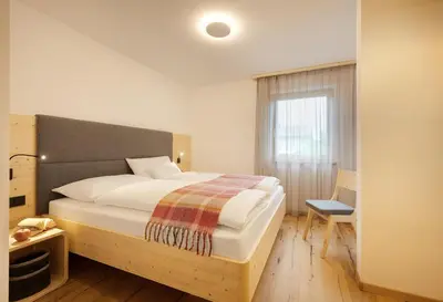 a bedroom with a large bed and a window at Ariala Apartments in Falzes
