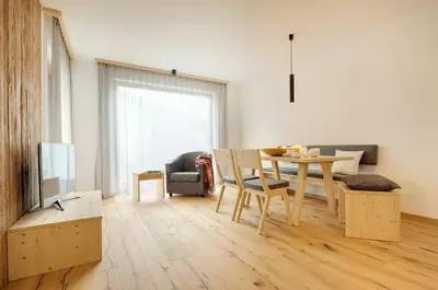 a living room with a table and a dining room at Ariala Apartments in Falzes