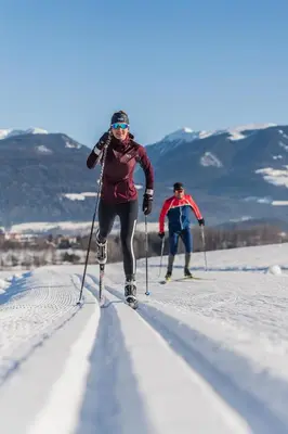 two people are cross country skiing in the snow at Ariala Apartments in Falzes