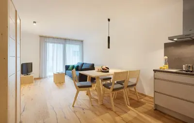 a kitchen and dining room with a table and chairs at Ariala Apartments in Falzes