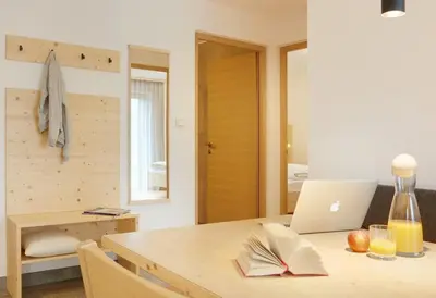 a table with a laptop and a book on it at Ariala Apartments in Falzes