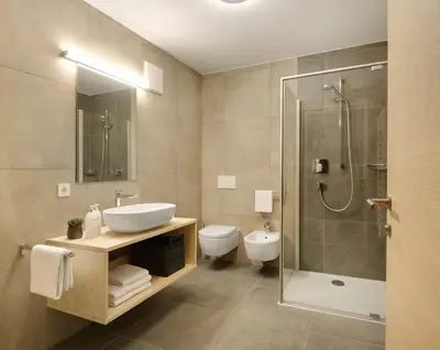 a bathroom with a sink and a shower and a toilet at Ariala Apartments in Falzes