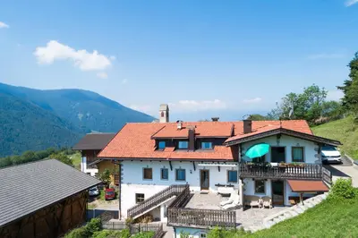 a house on a hill with mountains in the background at Oberpiskoihof in Funes