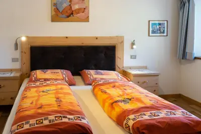 a bedroom with two beds and a large headboard at Oberpiskoihof in Funes