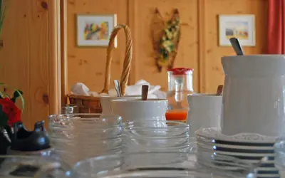 a table with bowls and cups and plates on it at Gasthof Weidmannshof in Bressanone