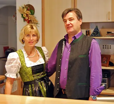 a man and a woman standing in a kitchen at Gasthof Weidmannshof in Bressanone
