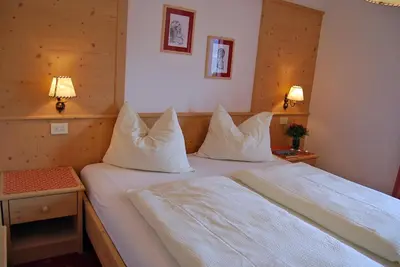 a bedroom with two beds with white sheets and pillows at Gasthof Weidmannshof in Bressanone