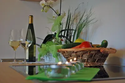 a basket of vegetables and wine glasses on a table at Gasthof Weidmannshof in Bressanone