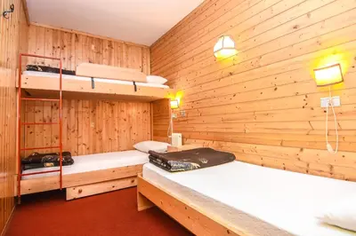 a room with two bunk beds in a wooden wall at Appartamenti Dolomiti con piscina e sauna in Cavalese