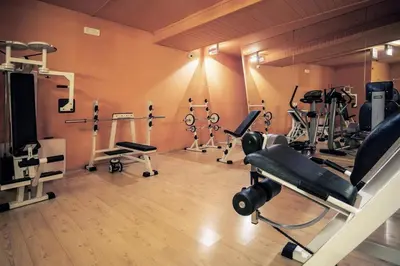 a room with a kitchen and a table and chairs at Appartamenti Dolomiti con piscina e sauna in Cavalese
