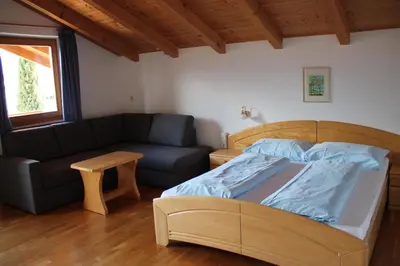a bedroom with a bed and a couch at Blummerhof in Lagundo