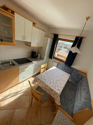 a small kitchen with a table and a table and chairs at Blummerhof in Lagundo