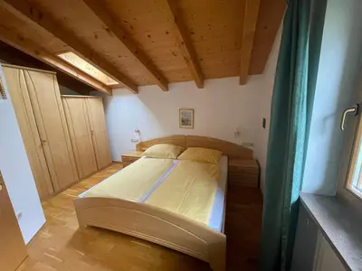 a bedroom with a bed in a room with wooden ceilings at Blummerhof in Lagundo