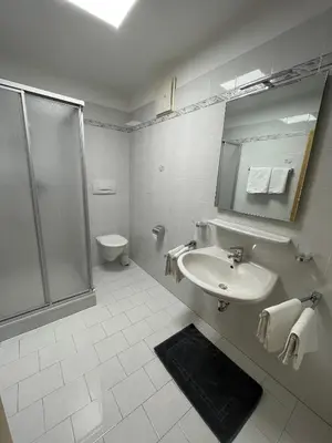 a white bathroom with a shower and a sink at Blummerhof in Lagundo