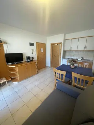 a living room with a table and a kitchen at Blummerhof in Lagundo
