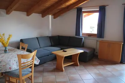 a living room with a blue couch and a table at Blummerhof in Lagundo