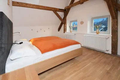 a bedroom with a bed with an orange blanket at Aurturist Brunico in Brunico