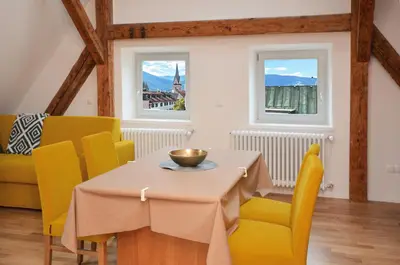 a dining room with a table and yellow chairs at Aurturist Brunico in Brunico