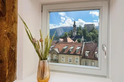 a vase with flowers sitting on a window sill at Aurturist Brunico in Brunico