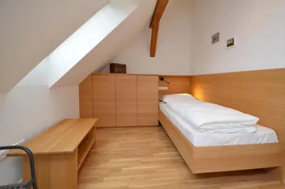 a small bedroom with a bed and a desk at Aurturist Brunico in Brunico
