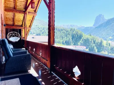 a balcony of a cabin with a view of the mountains at Chalet Bernardi Apartments in Ortisei