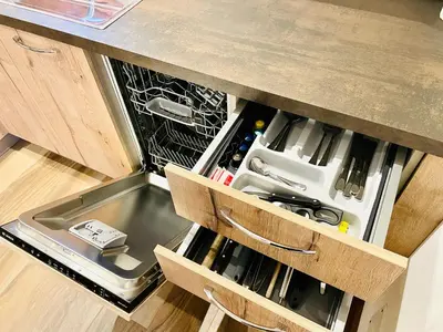 an open drawer in a kitchen with an open refrigerator at Chalet Bernardi Apartments in Ortisei