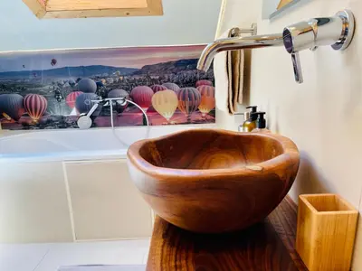 a wooden bowl sink in a bathroom at Chalet Bernardi Apartments in Ortisei