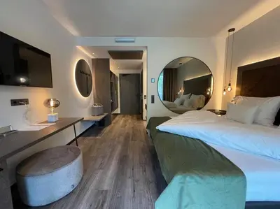 a hotel room with a large bed and a mirror at Appius Design Suites B&B - ADULTS ONLY in Appiano sulla Strada del Vino