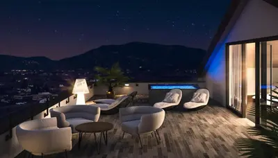 a balcony with chairs and tables at night at Appius Design Suites B&B - ADULTS ONLY in Appiano sulla Strada del Vino