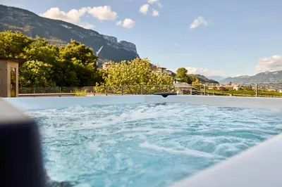 a hot tub with mountains in the background at Appius Design Suites B&B - ADULTS ONLY in Appiano sulla Strada del Vino