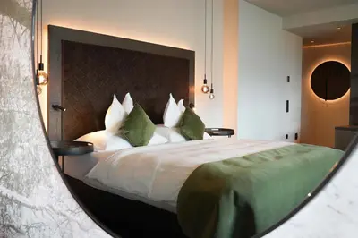 a bedroom with a large bed with green and white pillows at Appius Design Suites B&B - ADULTS ONLY in Appiano sulla Strada del Vino