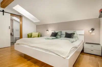 a bedroom with a large white bed with green pillows at Haus Lasaun in Bressanone