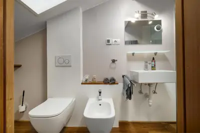 a white bathroom with a toilet and a sink at Haus Lasaun in Bressanone