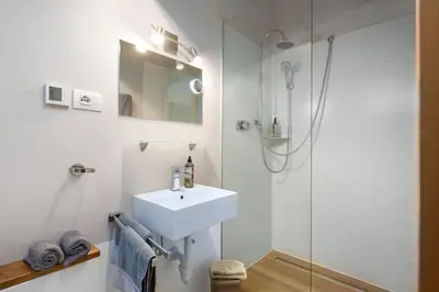 a white bathroom with a sink and a shower at Haus Lasaun in Bressanone
