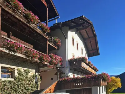 a white building with flowers on the balconies at Hanslerhof in Braies