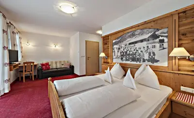 a bedroom with a large white bed in a room at Hotel Pfandleralm in San Martino