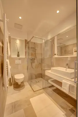 a bathroom with a shower and a toilet and a sink at Garni Hotel Kessler in Tirolo