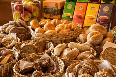 a table with baskets of different types of bread at Garni Hotel Kessler in Tirolo