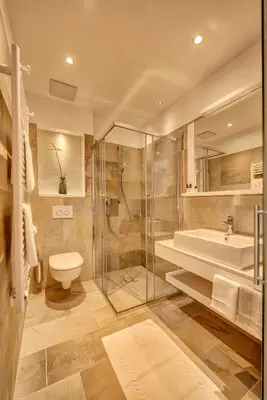 a bathroom with a shower and a toilet and a sink at Garni Hotel Kessler in Tirolo