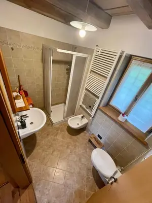 a bathroom with two sinks and a toilet and a window at Agriturismo Maso Fumas in Canale dʼAgordo
