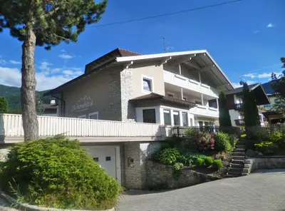 a large white house with a white garage at Haus Schönblick in San Lorenzo di Sebato