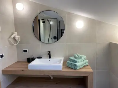 a bathroom with a sink and a mirror and towels at Haus Schönblick in San Lorenzo di Sebato